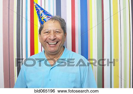 Stock Photograph - Hispanic man in party hat. Fotosearch