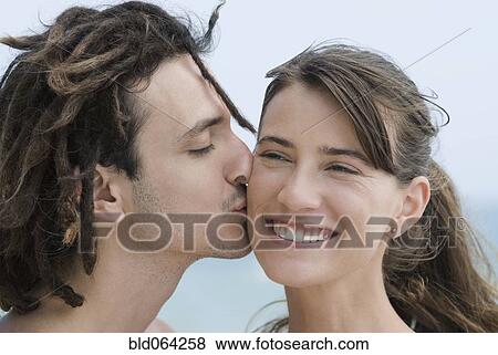 Stock Photo - Hispanic man kissing girlfriend. Fotosearch