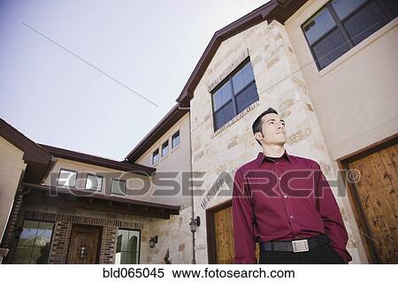Hispanic man standing outside house View Large Photo Image Stock Photography - Hispanic man standing outside house. Fotosearch