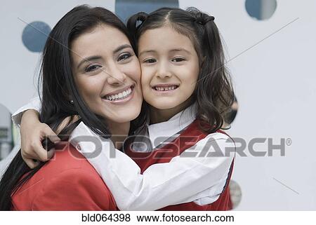 Stock Photo - Hispanic mother hugging daughter. Fotosearch