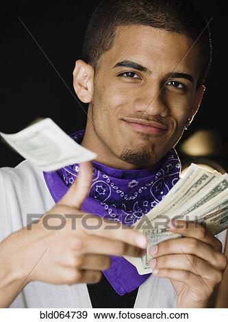 Stock Photo - Hispanic teenage boy throwing money. Fotosearch