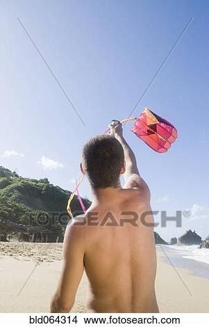Hispanic teenager flying kite at beach View Large Photo Image Picture - Hispanic teenager flying kite at beach. Fotosearch
