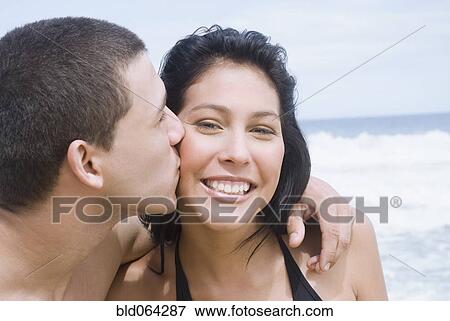 Stock Photo - Hispanic teenager kissing his girlfriend. Fotosearch