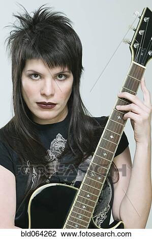 Hispanic woman holding guitar View Large Photo Image Stock Image - Hispanic woman holding guitar. Fotosearch