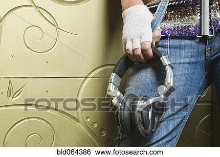 Hispanic woman holding headphones View Large Photo Image Stock Photograph - Hispanic woman holding headphones. Fotosearch