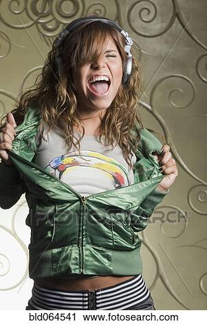 Stock Image - Hispanic woman in headphones dancing. Fotosearch