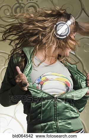 Stock Image - Hispanic woman in headphones dancing. Fotosearch