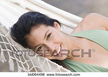 Stock Photo - Hispanic woman laying in hammock. Fotosearch