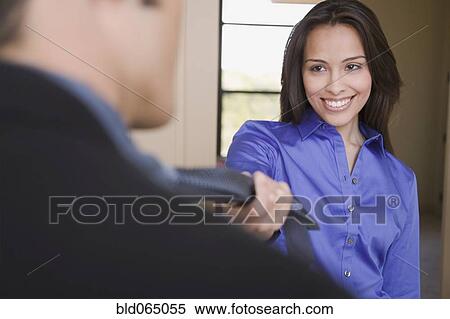 Stock Photography - Hispanic woman leading husband into the bedroom. Fotosearch
