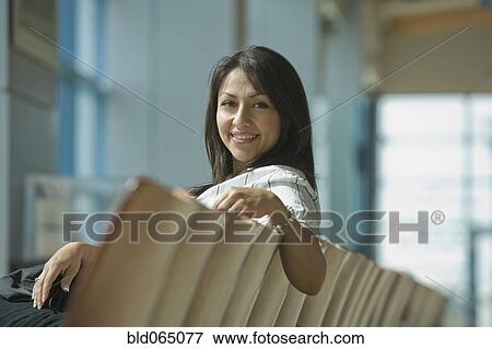 Stock Photo - Hispanic woman waiting in airport. Fotosearch
