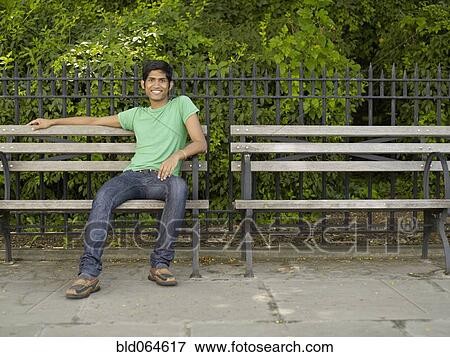 Stock Photo - Indian man relaxing on park bench. Fotosearch