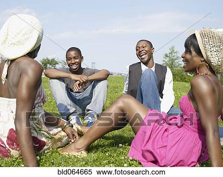 Stock Photography - Laughing African friends sitting in park. Fotosearch