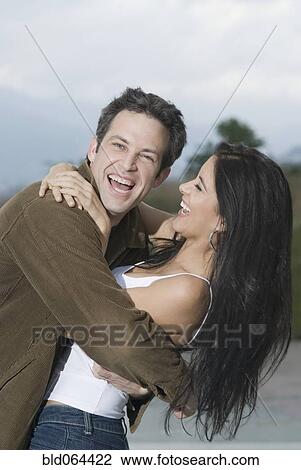 Laughing Hispanic couple hugging View Large Photo Image Stock Image - Laughing Hispanic couple hugging. Fotosearch