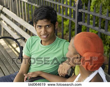 Stock Photo - Man and woman talking on park bench. Fotosearch
