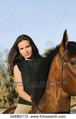Stock Image - Middle Eastern woman riding horseback. Fotosearch