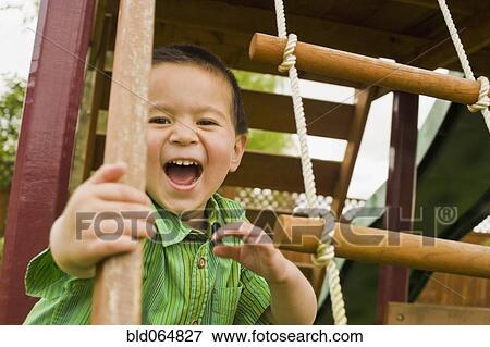 Stock Photo - Mixed race boy playing in playground. Fotosearch