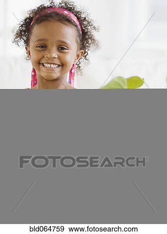 Mixed race girl watering plants View Large Photo Image Stock Photo - Mixed race girl watering plants. Fotosearch