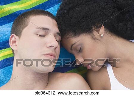 Multi-ethnic couple sleeping at beach View Large Photo Image Stock Image - Multi-ethnic couple sleeping at beach. Fotosearch