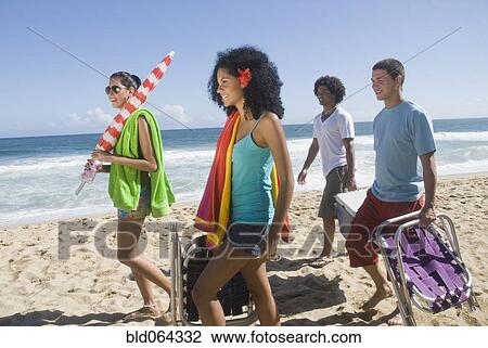 Stock Image - Multi-ethnic friends enjoying the beach. Fotosearch