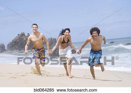 Multi-ethnic friends running on beach View Large Photo Image Stock Photography - Multi-ethnic friends running on beach. Fotosearch