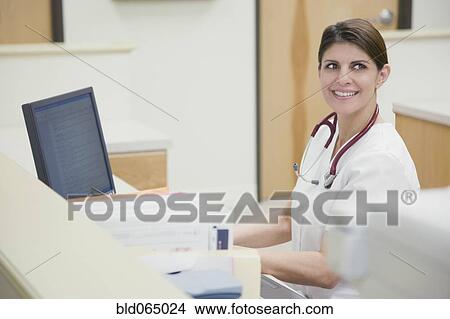 Picture - Nurse working at nurse’s station. Fotosearch