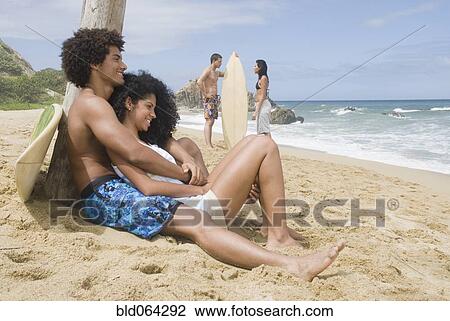 People relaxing at beach with surfboards View Large Photo Image Stock Image - People relaxing at beach with surfboards. Fotosearch