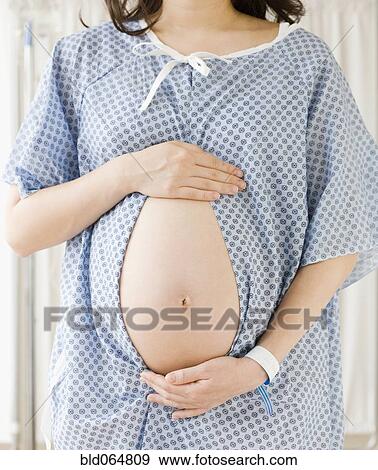 Stock Photo - Pregnant Asian woman having checkup in doctor’s office. Fotosearch