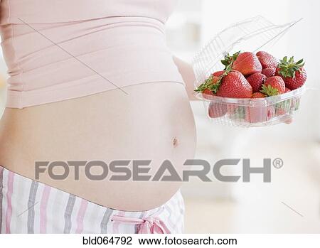 Pregnant Asian woman holding strawberries View Large Photo Image Stock Image - Pregnant Asian woman holding strawberries. Fotosearch