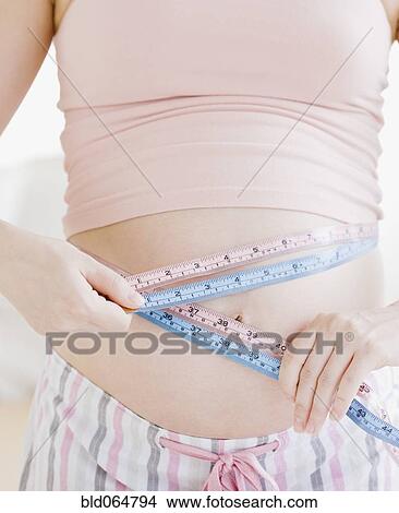Pregnant Asian woman measuring stomach View Large Photo Image Picture - Pregnant Asian woman measuring stomach. Fotosearch