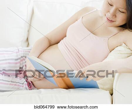 Stock Photo - Pregnant Asian woman reading book. Fotosearch