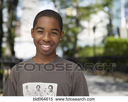 Stock Photography - Smiling African teenage boy in urban park. Fotosearch