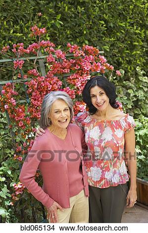 Smiling friends standing in garden View Large Photo Image Picture - Smiling friends standing in garden. Fotosearch