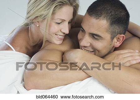 Smiling Hispanic couple laying in bed View Large Photo Image Stock Image - Smiling Hispanic couple laying in bed. Fotosearch