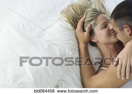 Smiling Hispanic couple laying in bed View Large Photo Image Stock Photo - Smiling Hispanic couple laying in bed. Fotosearch