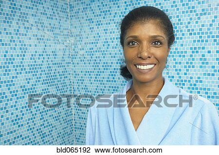 Stock Image - Smiling mixed race woman in bathroom. Fotosearch