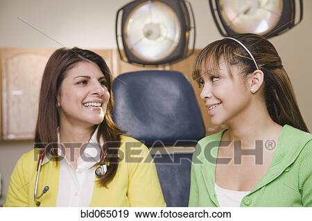 Stock Photo - Teenage girl having checkup in doctor’s office. Fotosearch