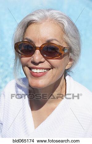 Woman at poolside in bathrobe and sunglasses View Large Photo Image Picture - Woman at poolside in bathrobe and sunglasses. Fotosearch
