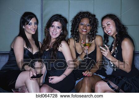 Women drinking cocktails in nightclub View Large Photo Image Stock Photo - Women drinking cocktails in nightclub. Fotosearch
