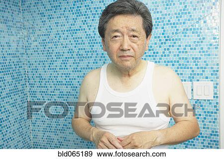 Stock Photo - Worrying Asian man in bathroom. Fotosearch