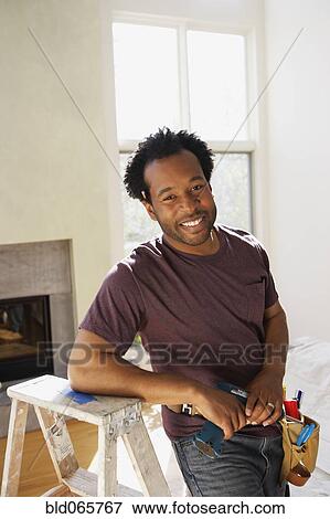 Stock Photo - African carpenter in livingroom. Fotosearch