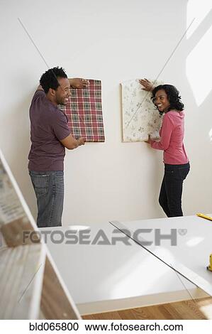 Stock Image - African couple choosing wallpaper. Fotosearch