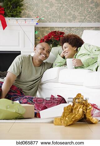 Stock Photo - African couple in living room on Christmas morning. Fotosearch