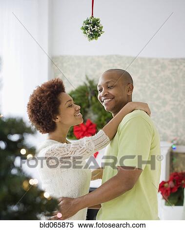 African couple kissing underneath mistletoe View Large Photo Image Stock Photography - African couple kissing underneath mistletoe. Fotosearch