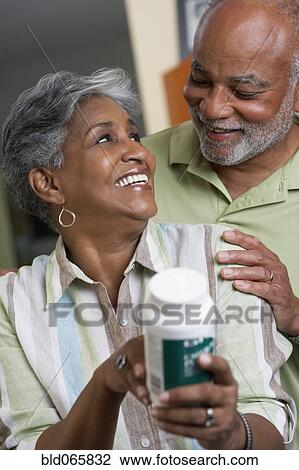 Stock Image - African couple reading vitamin ingredients. Fotosearch