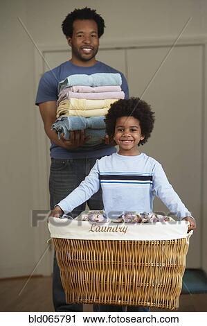 Stock Image - African father and son doing laundry. Fotosearch