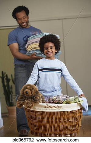 Stock Image - African father and son doing laundry. Fotosearch
