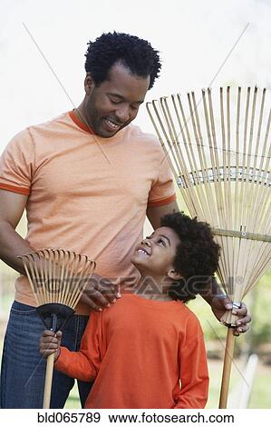 African father and son holding rakes View Large Photo Image Stock Photo - African father and son holding rakes. Fotosearch