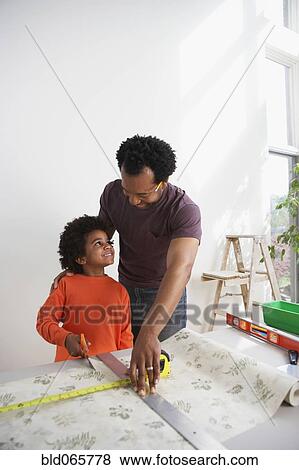 African father showing son how to measure wallpaper View Large Photo Image Stock Photo - African father showing son how to measure wallpaper. Fotosearch