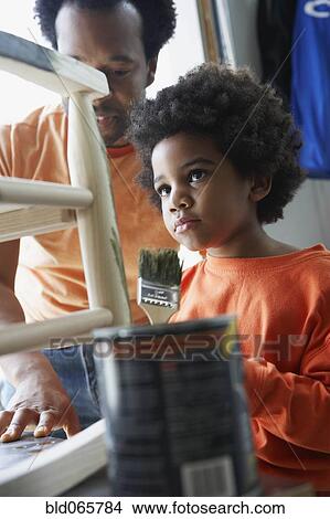 African father watching son paint rocking chair View Large Photo Image Picture - African father watching son paint rocking chair. Fotosearch