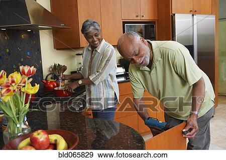 African man fixing kitchen cabinet for wife View Large Photo Image Stock Photo - African man fixing kitchen cabinet for wife. Fotosearch